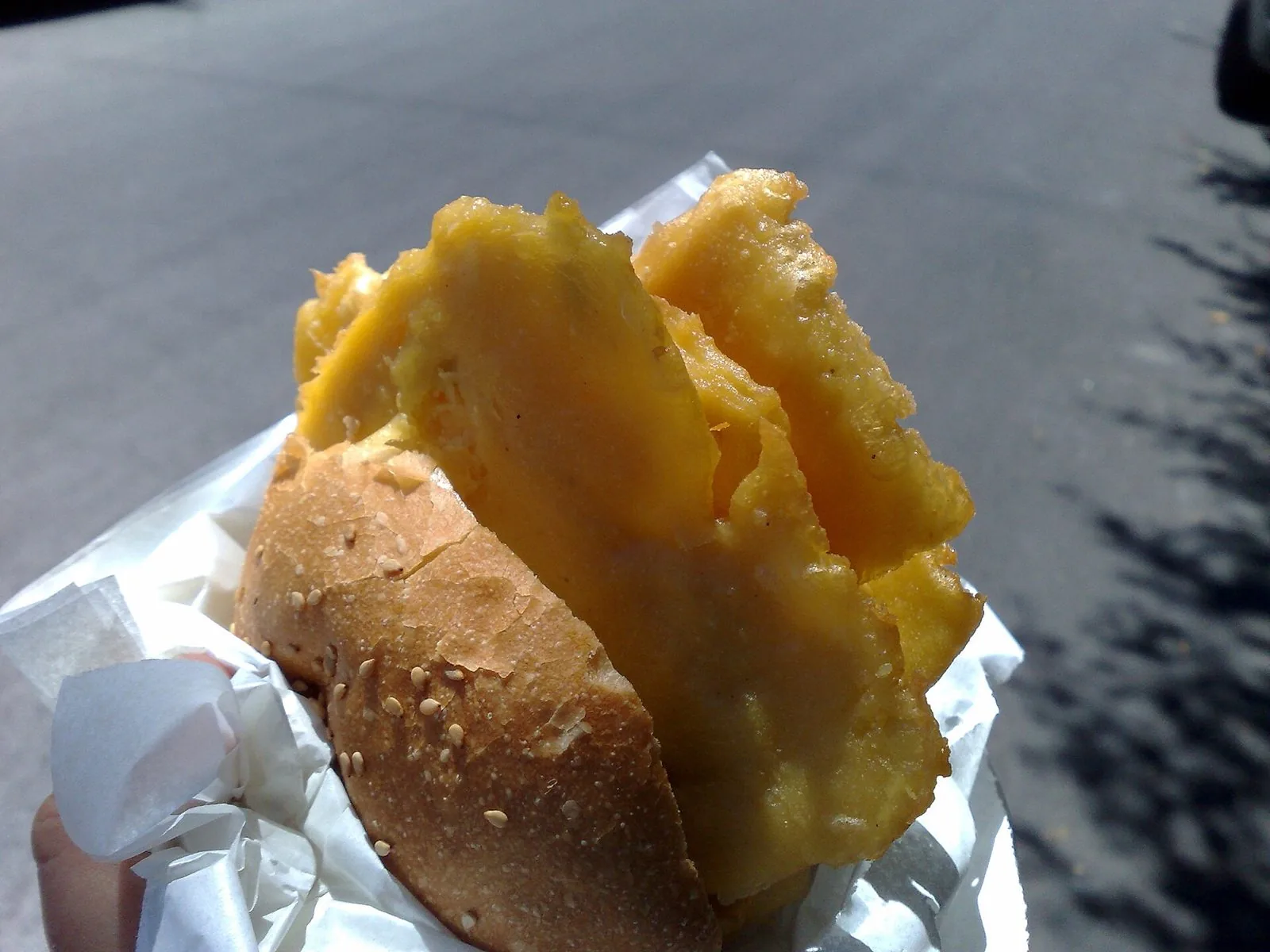 Pane e panelle: panino al sesamo farcito con frittelle di ceci, avvolto nella carta
