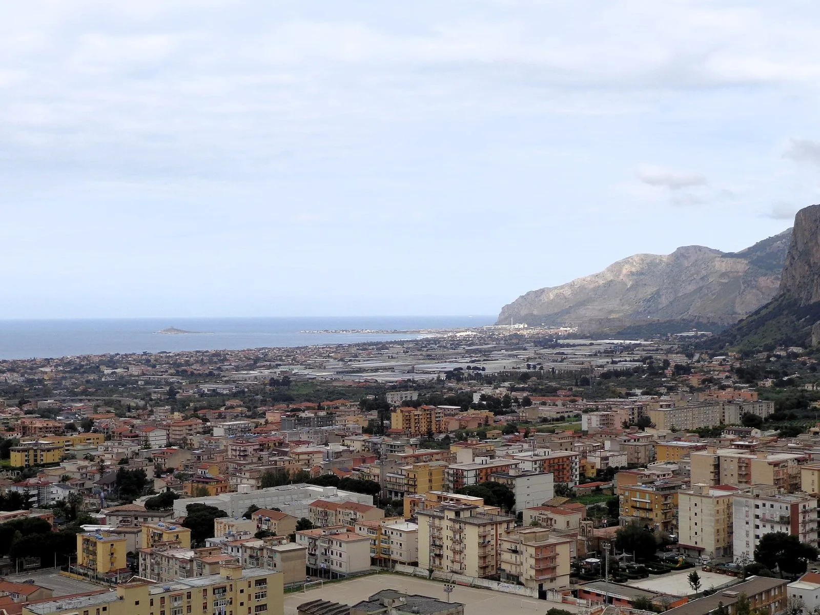 Panorama di Carini con i tetti del centro e le colline verdi alle spalle del paese in una giornata di fine marzo